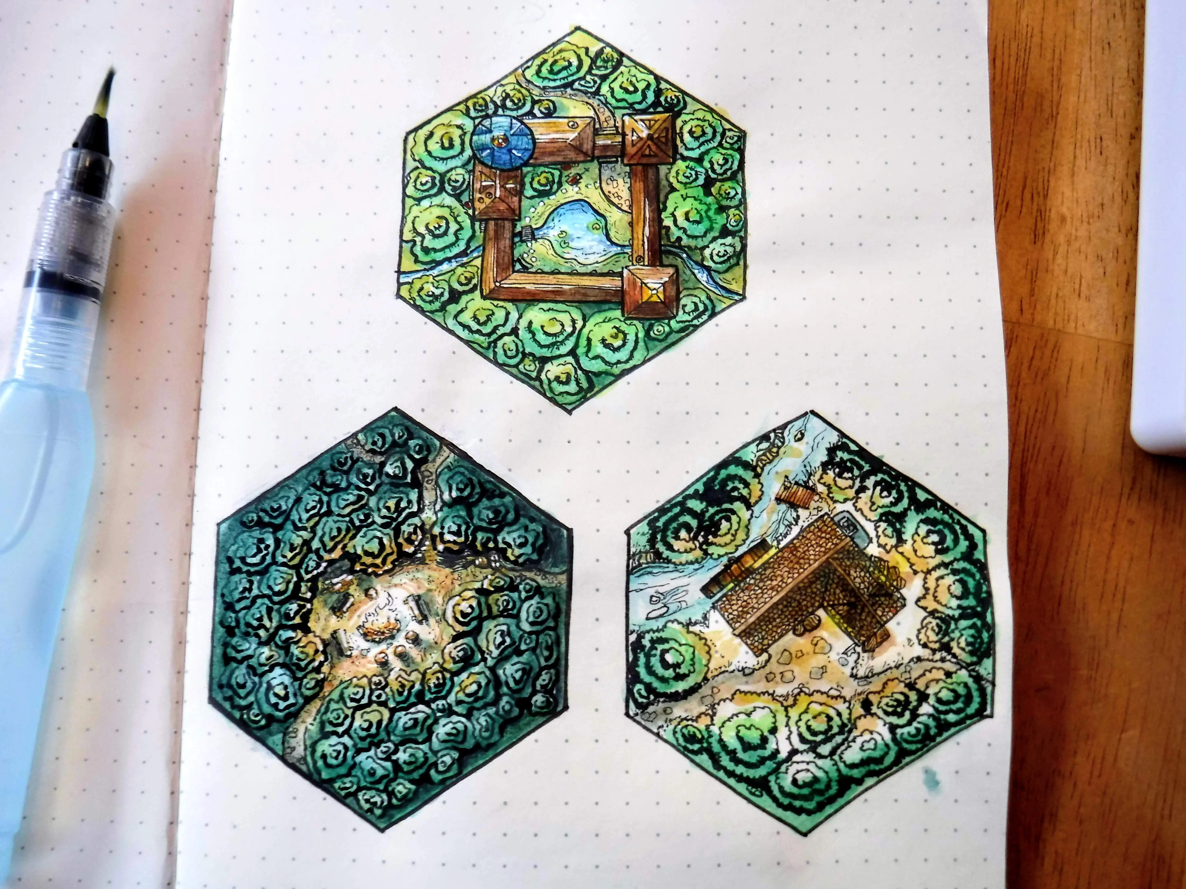 Three colorful fantasy terrain hexes painted on a dotted sketchbook page
